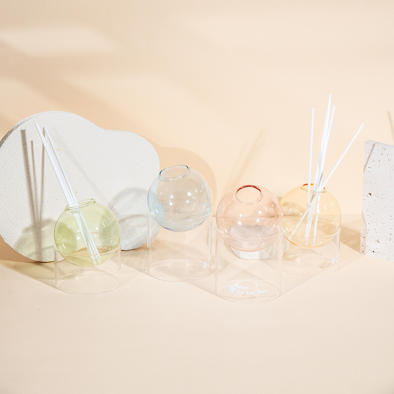 Przezroczysta szklana podstawa, szklana kulka z trzcinowym dyfuzorem stylizującym aromaterapię